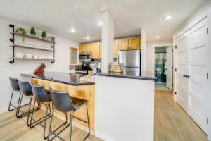 a kitchen with a counter and stools at a bar at Tree-Lined Hayden Home with Hot Tub and Lake Views! in Hayden