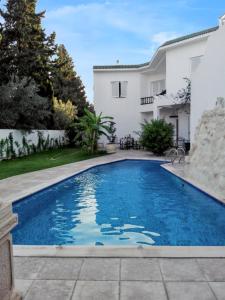 a swimming pool in the backyard of a house at 4 bedrooms villa with private pool enclosed garden and wifi at Hammamet in Hammamet