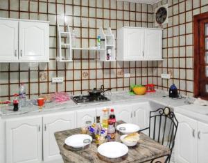 uma cozinha com armários brancos e uma mesa com comida em 4 bedrooms villa with private pool enclosed garden and wifi at Hammamet em Hammamet