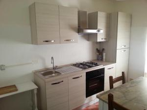 een keuken met een wastafel en een fornuis top oven bij B&B I Canonici in Urbino
