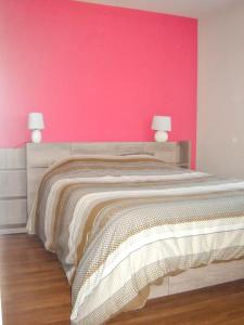 - une chambre avec un grand lit et un mur rose dans l'établissement Maison de 2 chambres avec jardin clos et wifi a La Vineuse, à La Vineuse