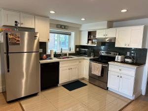a kitchen with white cabinets and a stainless steel refrigerator at Private room in a Shared house in Vancouver