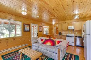 a living room with a couch and a kitchen at Pets Welcome Cozy Cabin with Deck in Deadwood! in Deadwood