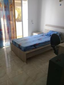 een slaapkamer met een bed, een bureau en een stoel bij maison à lagrotte bizerte tunisie in Bizerte