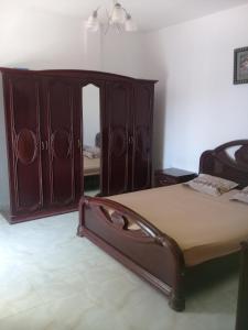 een slaapkamer met een bed en een grote houten kast bij maison à lagrotte bizerte tunisie in Bizerte