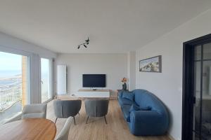 un soggiorno con un divano blu e una televisione di Touquet apartment facing the sea a Le Touquet-Paris-Plage