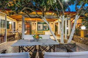 a patio with a table and chairs and trees at Katerina's garden Apartment 1 - Tertsa Ierapetra in Térsa