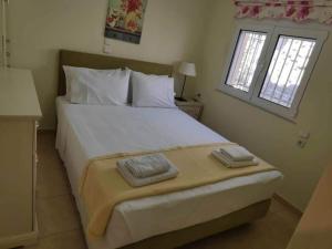 a bedroom with a large bed with two towels on it at Katerina's garden Apartment 1 - Tertsa Ierapetra in Térsa