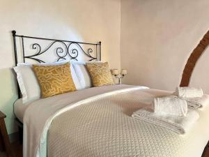 a bedroom with a large bed with white and gold pillows at Il Rifugio nel Chianti, Montefioralle apartament in Greve in Chianti