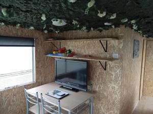 a small table with a television and a table with chairs at 6 Headwards Glamping Retreat in Hemsby