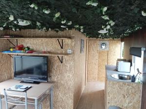 a living room with a tv and a table with a table sidx sidx at 6 Headwards Glamping Retreat in Hemsby