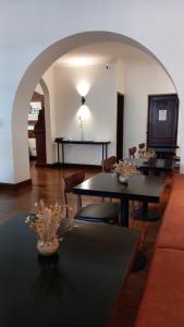una sala de estar con mesas y sillas y un arco en Hotel Del Virrey en Salta