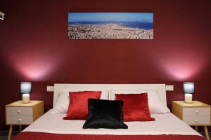 a bedroom with a white bed with red pillows at A casa di Stefy in Trapani