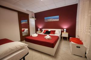 a bedroom with a red and white bed and a mirror at A casa di Stefy in Trapani