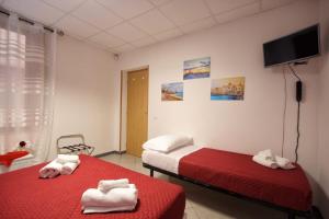 two beds in a room with red sheets and towels at A casa di Stefy in Trapani +29 photos