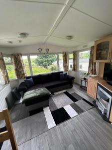 a living room with a black couch and a tv at Newquay buy resort Holiday in Newquay Bay Resort