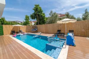 Una gran piscina con sombrilla y una piscina. en Erva Apart Fethiye, en Fethiye