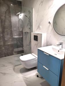 a bathroom with a toilet and a shower and a sink at Trzy Fale in Dąbrówno +44 photos