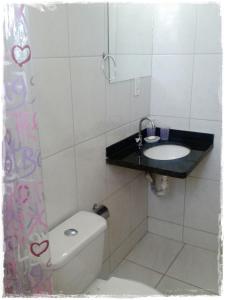 y baño con aseo y lavamanos. en Suítes de Setiba - HOSPEDARIA OCA RUCA, en Guarapari
