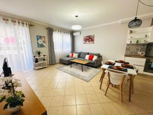 een woonkamer met een bank en een tafel bij Quiet & spacious city center apartment - 4 min walk in Tirana