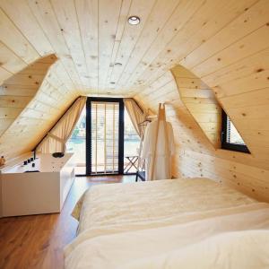 sypialnia z dużym łóżkiem w drewnianym suficie w obiekcie Kompleksi Turistik DEA w Szkodrze