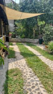 einen steinernen Gehweg mit Markise über einem Hof in der Unterkunft El Rinconcito de la Antigua in Antigua Guatemala
