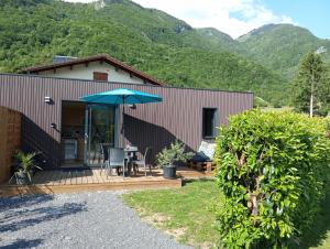 a house with a patio with a table and an umbrella at Maisonnette au calme in Marlens