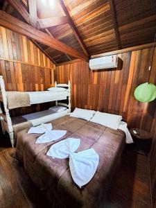 een kamer met 2 bedden in een houten hut bij Pousada Sabiá in Brotas