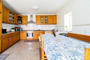 a kitchen with wooden cabinets and a table in it at Casa Monte Beira Rio in Touguinho
