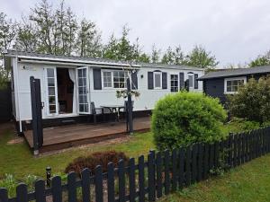 卡兰茨奥赫Chalet Callantsoog的白色的小房子,设有木甲板