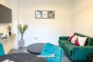 Una sala de estar con un sofá verde y una mesa. en Ashfield Co-living - Private Room Self-cater, en Mánchester