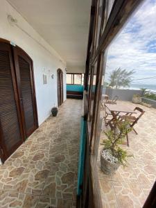 Blick auf eine Terrasse mit einem Tisch und einer Bank in der Unterkunft Casa de Praia Suítes in Saquarema