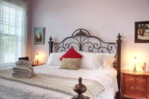 een slaapkamer met een groot bed met rode en witte kussens bij The Scotsman Inn in Pictou