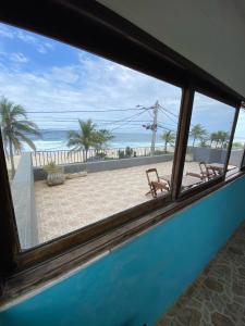 Blick auf den Strand aus dem Fenster in der Unterkunft Casa de Praia Suítes in Saquarema