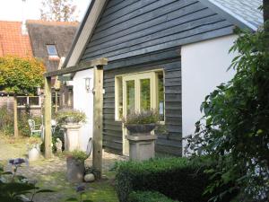 een huis met twee potplanten aan de zijkant bij Roing B&B in Hijken