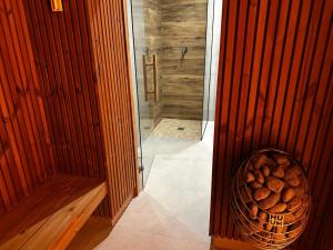 文盖尔斯卡－古尔卡WRZOS resort & wellness **** DOMKI CAŁOROCZNE的浴室设有淋浴,备有一篮木柴