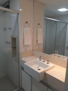 a bathroom with a sink and a shower and a mirror at GARVEY PARK HOTEL in Brasilia