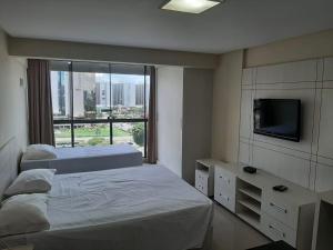 a bedroom with two beds and a flat screen tv at GARVEY PARK HOTEL in Brasilia