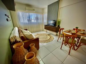 a living room with a couch and a dining room at Apartamento Luxo com Piscina em Ponta Verde in Maceió
