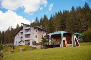 a large building on a hill with trees in the background at Zlatarska kruna in Nova Varoš