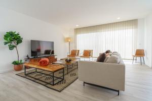 un salon avec un canapé et une télévision dans l'établissement Villa Mauricio, à Mariquiteira
