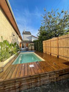 uma piscina num deque de madeira com cerca em Chambre salle de bain privée avec piscine à 20 minutes de Paris em Fontenay-sous-Bois