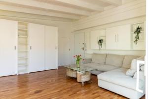 a living room with a white couch and a glass table at Attico New Bussola Cagliari in Cagliari