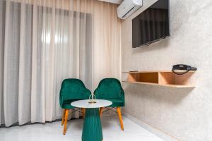 Maarif Elite Suites في الدار البيضاء: كرسي أخضر وطاولة في الغرفة