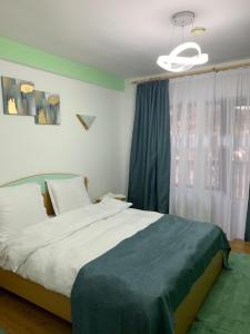 een slaapkamer met een groot bed en een raam bij Pensiunea Mario in Moieciu de Sus