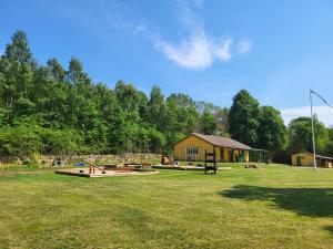 un parque con bancos y un edificio en un campo en Ormanäs Stugby, en Höör