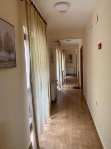 a long hallway with curtains and a long hallway with a hallwayngth at Pensiunea Mario in Moieciu de Sus