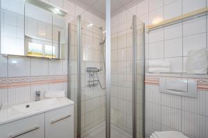 un baño con ducha y lavabo en Bungalow Nici, en Westerland