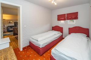 2 camas en una habitación pequeña con divisores rojos en Bungalow Nici, en Westerland