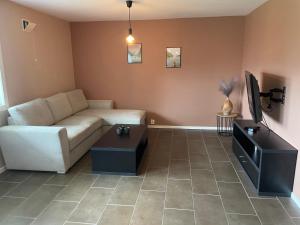 a living room with a couch and a tv at Slinningen Apartment with free parking in Ålesund
